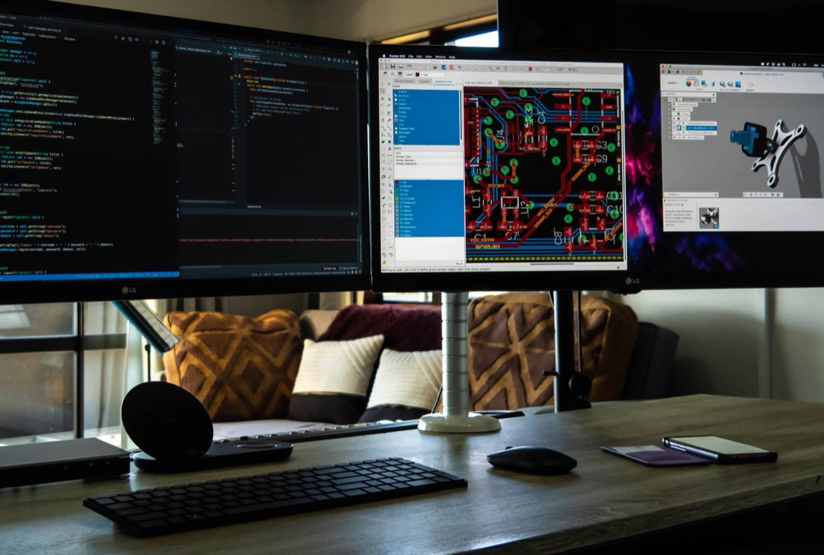 Workstation showing code, a PCB layout and a 3D model